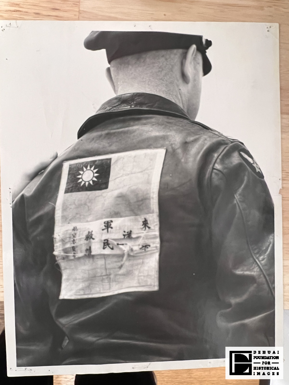 TFA-CA-119 — The print: a man photographed from behind, with the Chinese blood chit sewn across the back of his leather jacket.